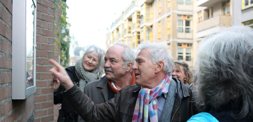 Bij de vitrines in de Sint Antoniesbreestraat wordt de expositie van foto's van de geschiedenis van de Sint Antoniesbreestraat geopend met een rondleiding