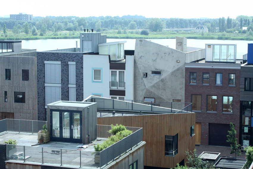 Exterieur van het leemwand-huis tussen de meer naar nederlandse traditie opgetrokken huizen